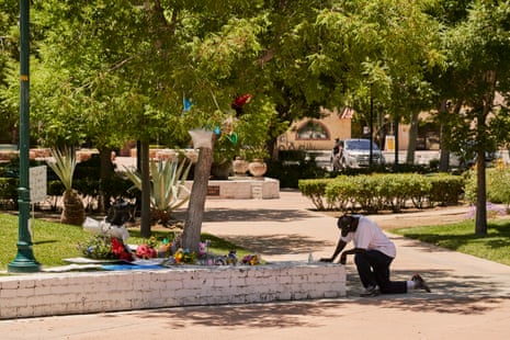 A man kneels near the tree where the body of Robert Fuller was found hanging, in Palmdale, California.