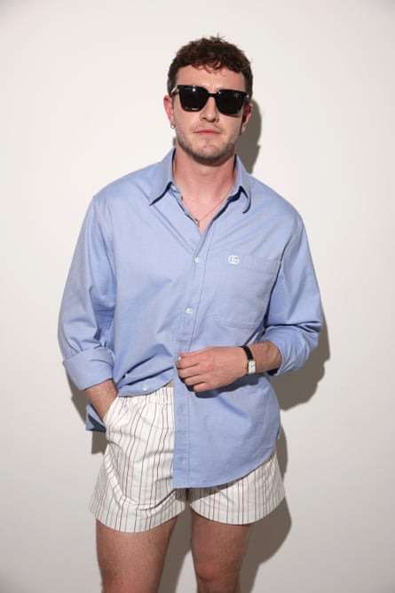 Actor Paul Mescal in a blue shirt, boxer shorts and black sunglasses.