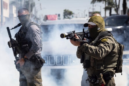 An officer takes aim at a crowd.
