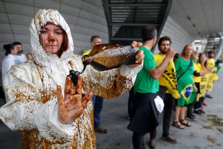 A climate activist pours oil on her hands during a demonstration outside the Palais des Congrès, Paris, after environmentalists disrupted Total’s annual shareholders meeting in protest against its plan to the drill in the Amazon basin.