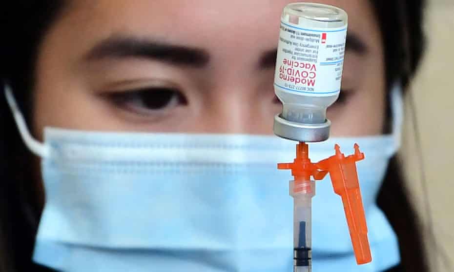 Person fills syringe with Moderna vaccine