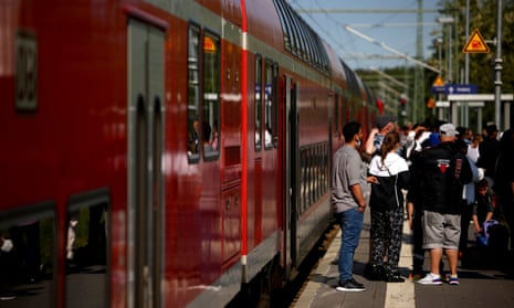 Passengers wait on a platform in Kratzeburg beside a regional train to Rostock