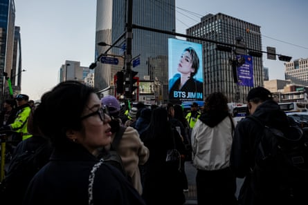 People walk through the streets at the venue ahead of the BTS comeback concert in Seoul