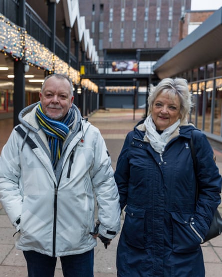 man and woman stand in an empty shopping centre