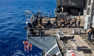 US Navy sailors raise a larne target from the fantail of the aircraft carrier USS Theodore Roosevelt in the Philippine Sea 21 March, 2020.