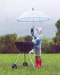 Boy barbecuing in the rain