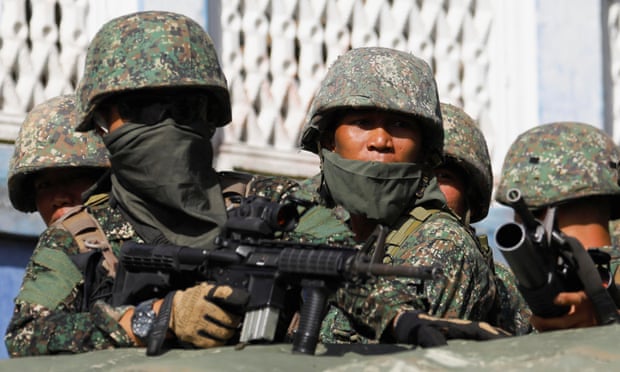 Troops aboard a vehicle as more soldiers reinforce to fight the Maute group in Marawi in southern Philippines.
