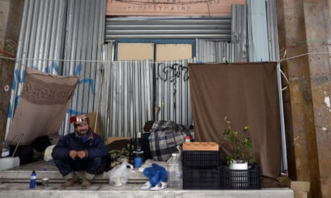 A homeless man sits the former education ministry in Athens