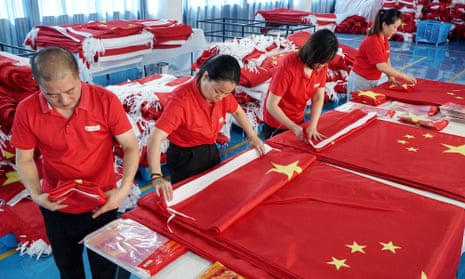 Workers make flags at a factory in Wuyi, Zhejiang, ahead of national day. The country’s economy is showing signs of slowing down.
