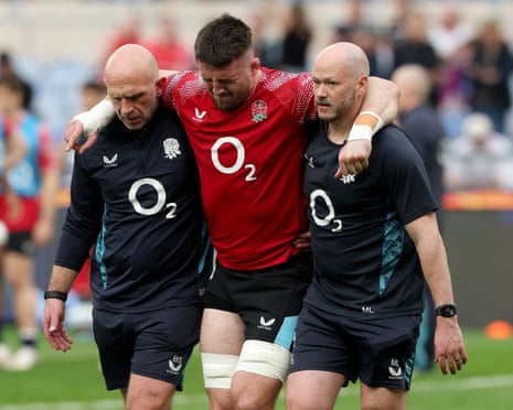 Tom Curry of England leaves the pitch following medical treatment after picking up an injury in the warm up prior to the Six Nations match against Italy.