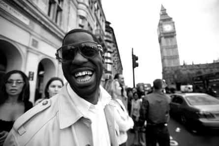 black and white photo of a man smiling in front of big ben