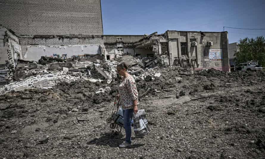 A woman walks in front of a building destroyed by a strike.