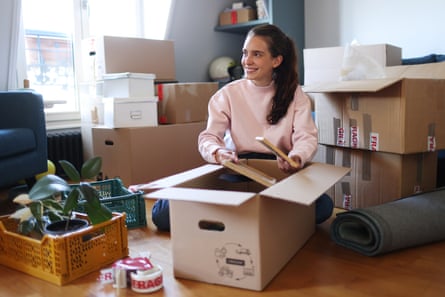 A young woman packing boxes.