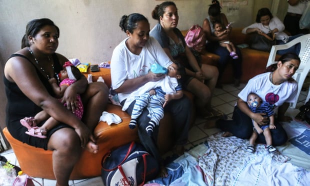 Infants born with microcephaly – a birth defect linked to the Zika virus in expectant mothers – are held by mothers and family members at a meeting in Recife, Brazil.