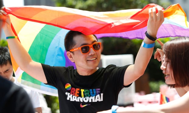 A man holds a rainbow flag in Shanghai. 