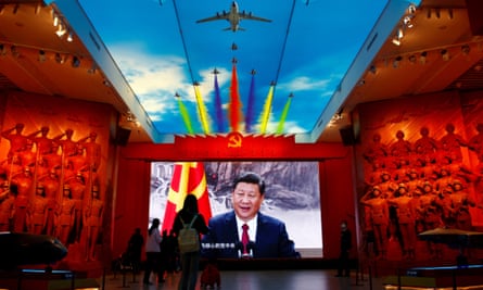 Vizitatorii stau in fata unui ecran gigant in care se afiseaza Xi Jinping langa un steag al Partidului Comunist din China, la Muzeul Militar al Revolutiei Populare Chineze din Beijing.