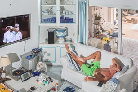 Andrea Squarci, 69, watches a tennis match on TV during a heatwave at Lido dei Pini, a seaside location about an hour away from Rome, Italy. The house where Andrea lives with his wife Chiara, since his retirement in 2019, is right in front of the sea.