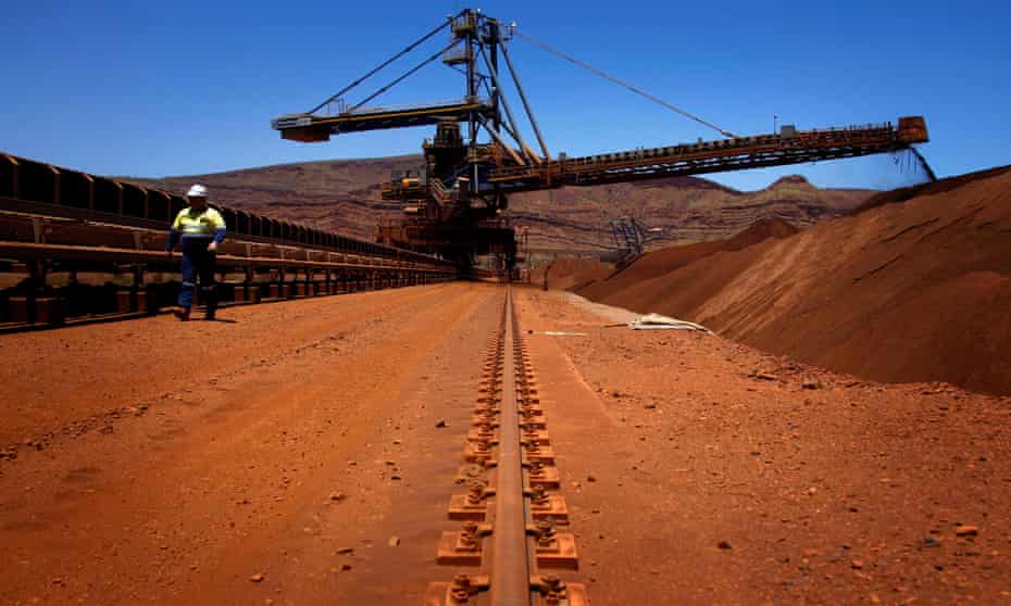 A mine worker inspects conveyer belts transporting iron ore at the Fortescue Solomon iron ore mine in the Pilbara region of Western Australia.