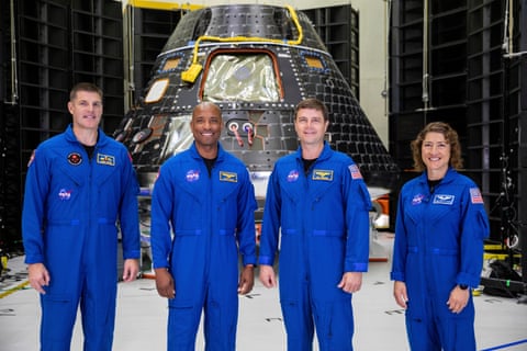 Artemis II crew members stand in front of the Orion capsule