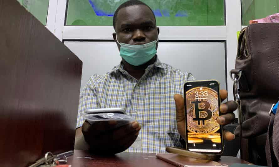 Abolaji Odunjo, a gadget vendor who uses bitcoin, poses with his mobile phone