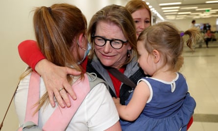 Passengers reunite with family members after arriving at Perth airport on Saturday