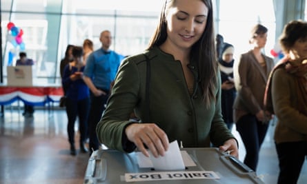 A young person puts their voting slip in a ballot box