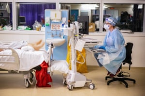 Dr Simpson sits with a patient on the Covid ICU ward.
