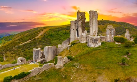 Dramatic sunset over the Corfe Castle, Dorset, EnglandCorfe Castle is a fortification standing above the village of the same name on the Isle of Purbeck peninsula in the English county of Dorset. Built by William the Conqueror, the castle dates to the 11th century and commands a gap in the Purbeck Hills on the route between Wareham and Swanage.