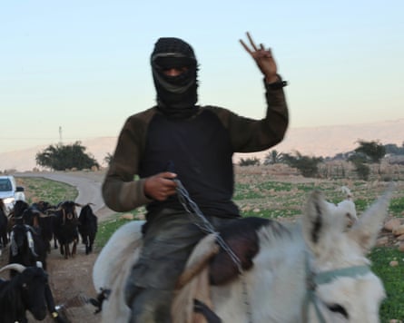 The Israeli settler shepherd, escorted by a white truck with Israeli soldiers.