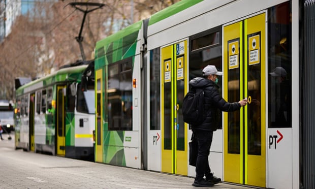 A member of the public wears a face mask as they board a tram.
