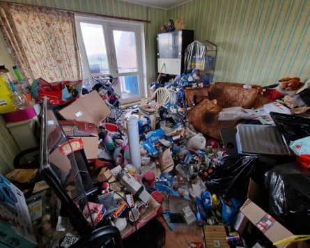 Possessions and litter cover every surface in a room