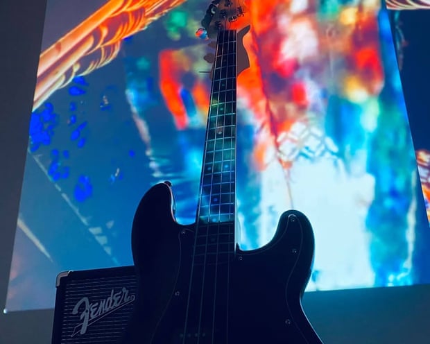 A bass guitar in front of a projected background