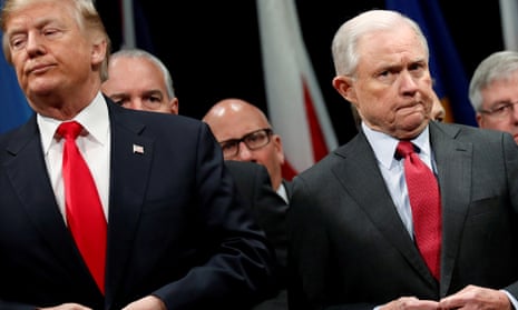 Donald Trump and Jeff Sessions button their coats as they stand for the national anthem at the FBI Academy in Quantico, Virginia in December 2017.