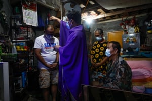 Members of the Espiritu family, who are unable to attend holy mass, receive ashes sprinkled on their head by a priest
