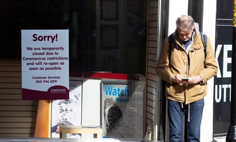 A man waits outside a closed shop on a street corner in Harrogate