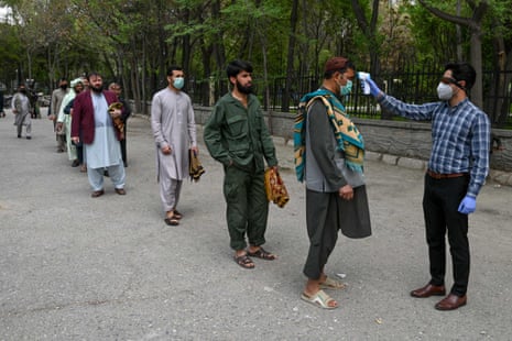A health worker checks the temperature of worshippers arriving at Wazir Akbar Khan mosque in Kabul on Friday
