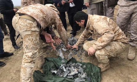 Iraqi security forces collect pieces of missile as they inspect the site after the attack on al-Asad airbase