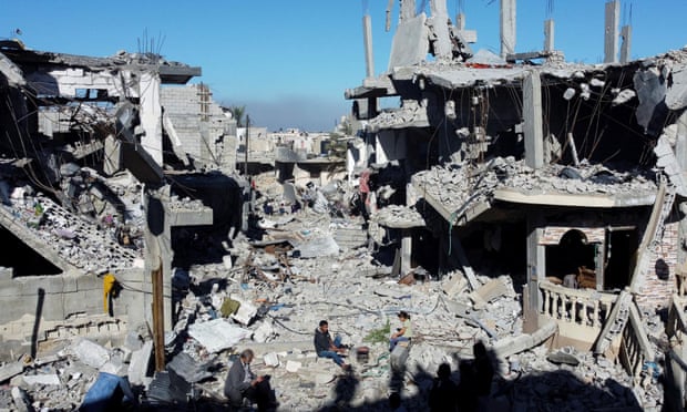 Palestinians cook among the houses destroyed in Israeli strikes, at Khan Younis refugee camp, on 29 November 2023. Reuters/Mohammed Salem