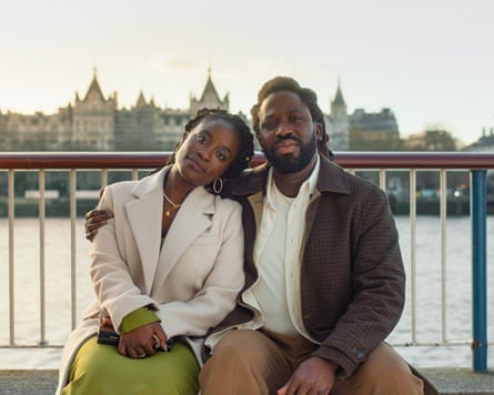 A film still from the show Dreaming Whilst Black. Here, actor Babirye Bukilwa leans against Adjani Salmon, who has an arm around her shoulder.