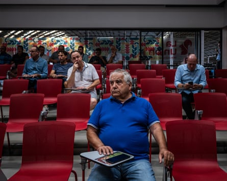 People sit on chairs at an auction.