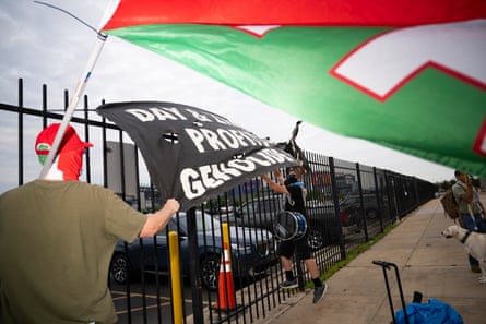 People fixing pro-Palestine banners to railings near a stadium