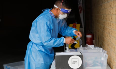A health worker handles a sample at a COVID-19 pop up drive through site in Melbourne, Wednesday, December 15, 2021. Hundreds of patrons at two Melbourne nightclubs will be forced to isolate for at least seven days after an Omicron-infected patron attended the venues. (AAP Image/Con Chronis) NO ARCHIVING