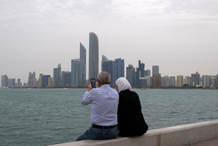 People sit by the water in Abu Dhabi in the UAE on Friday.