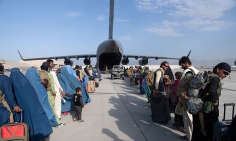 Two lines of people stretch out as they wait to board a US military aircraft.