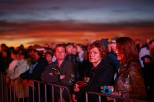 Crowds are bathed in pink light as they take part in the Anzac dawn service in Currumbin.