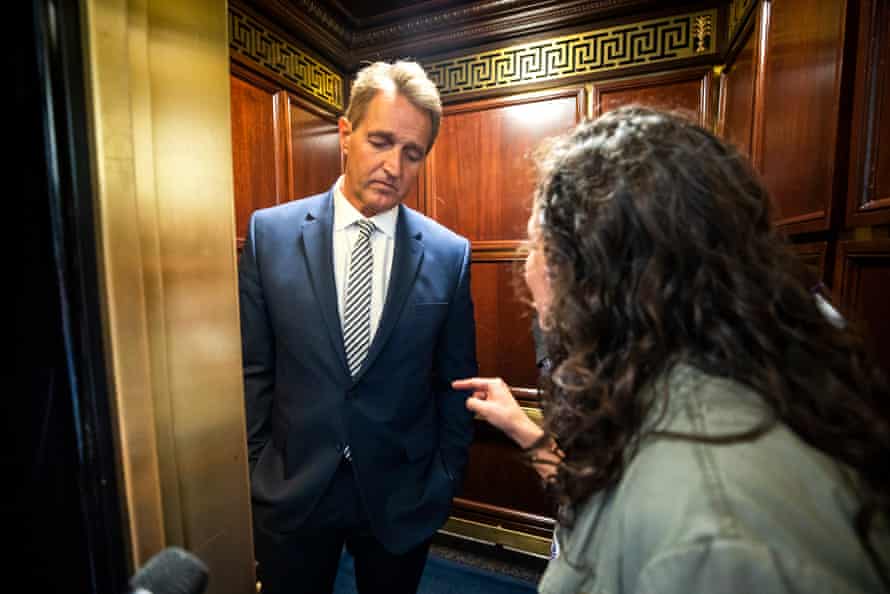 A protester confronts Senator Jeff Flake in a lift after he announces he is voting to confirm Brett Kavanaugh's nomination.