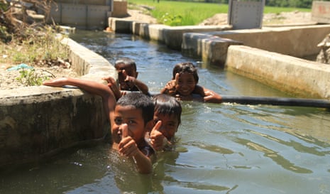 Children play in the irrigation channels near a dam in the special economic zone of Oecusse