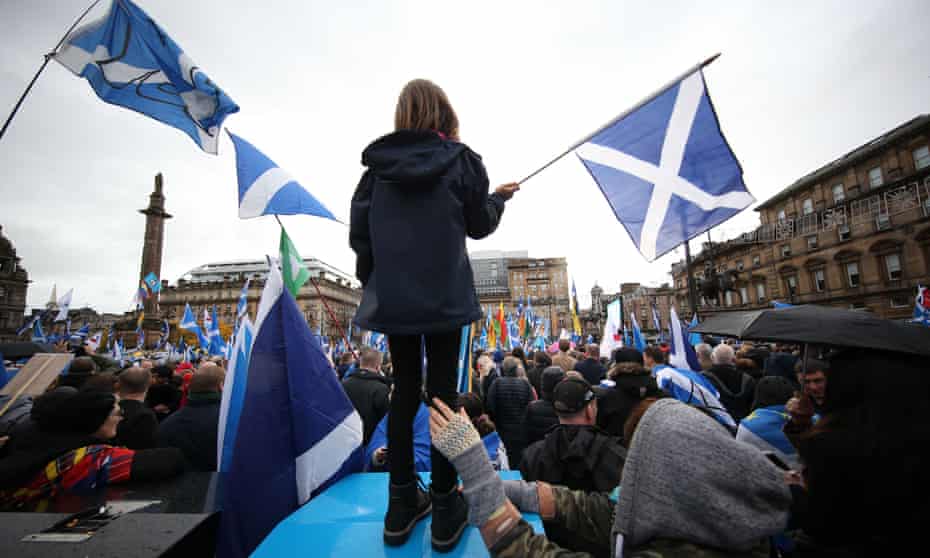 Eight-year-old Erin Burns, from Partick, waves a Scottish saltire flag while her mum, Katy Burns, steadies her at a Scottish independence rally in Glasgow on 2 November 2019.