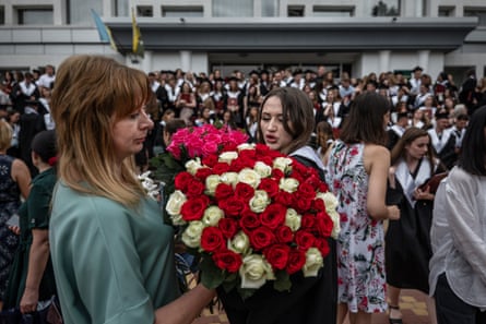 At Kyiv National University of Trade and Economics, students graduate and celebrate with flowers.