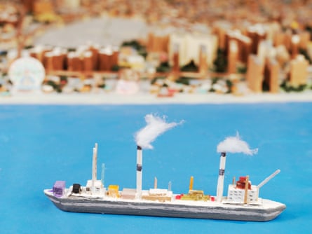 A tiny boat as part of a wooden model of New York City